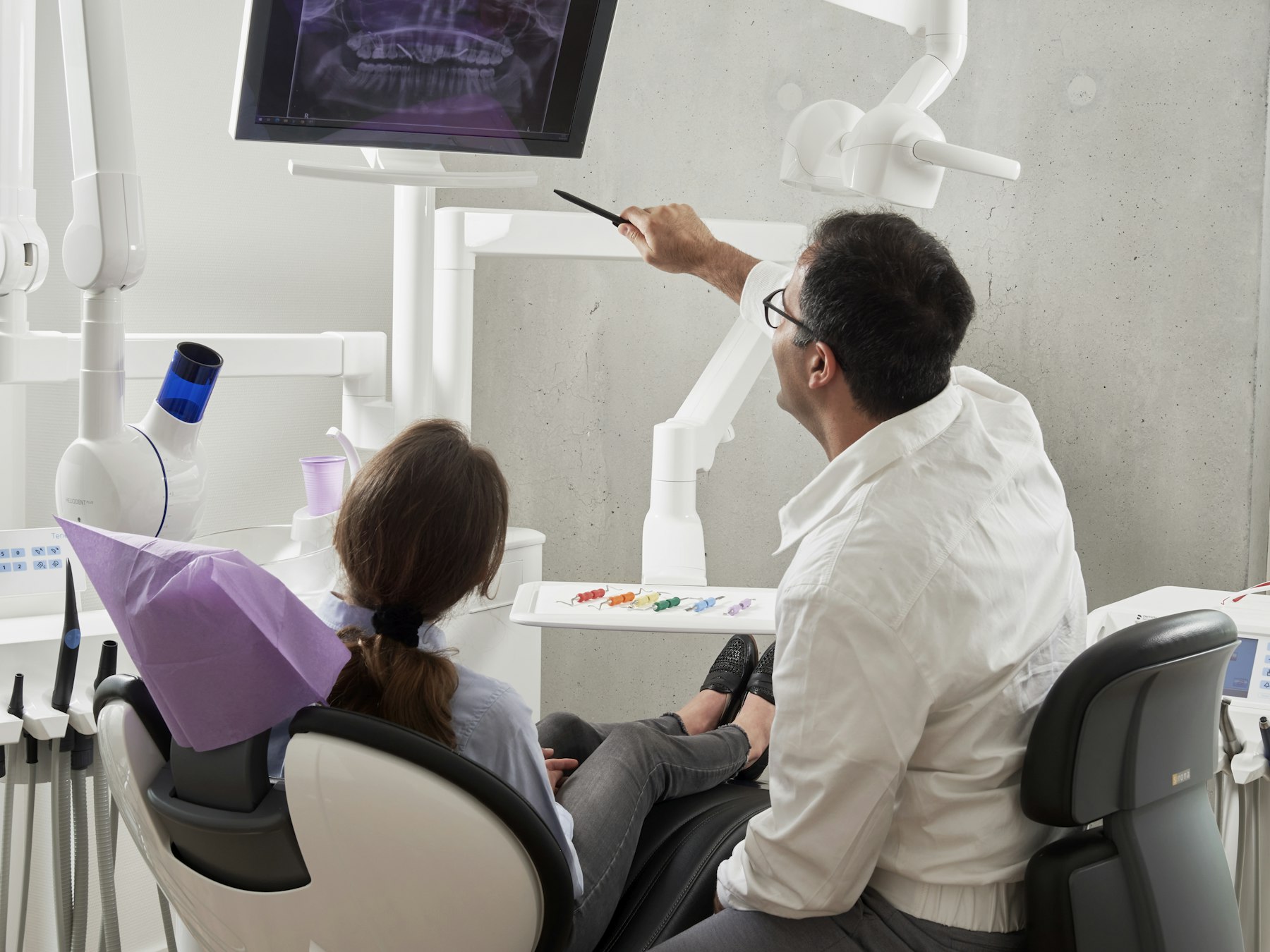 A dentist examining a patient in a bright, modern treatment room